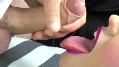 Чувак после дрочки спускает сочный поток спермы шлюхе на язык. Съемка крупным планом.